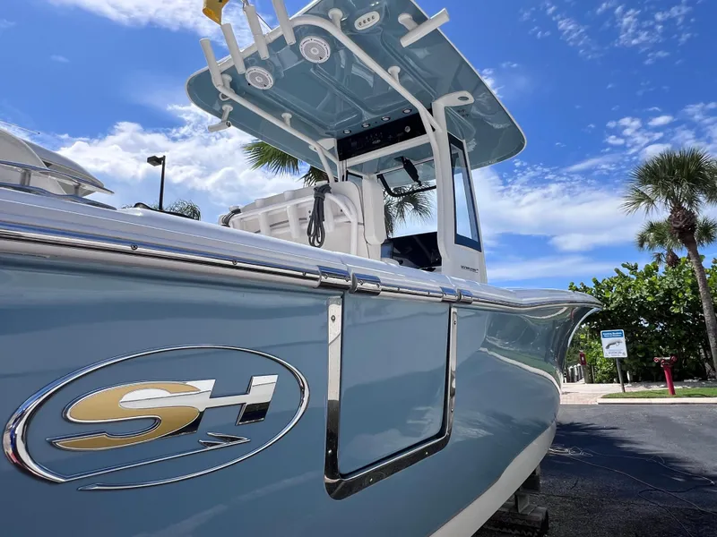 Slide: The Image of 2024 Sea Hunt Ultra 239 SE boat with sleek design under a clear blue sky. - 14