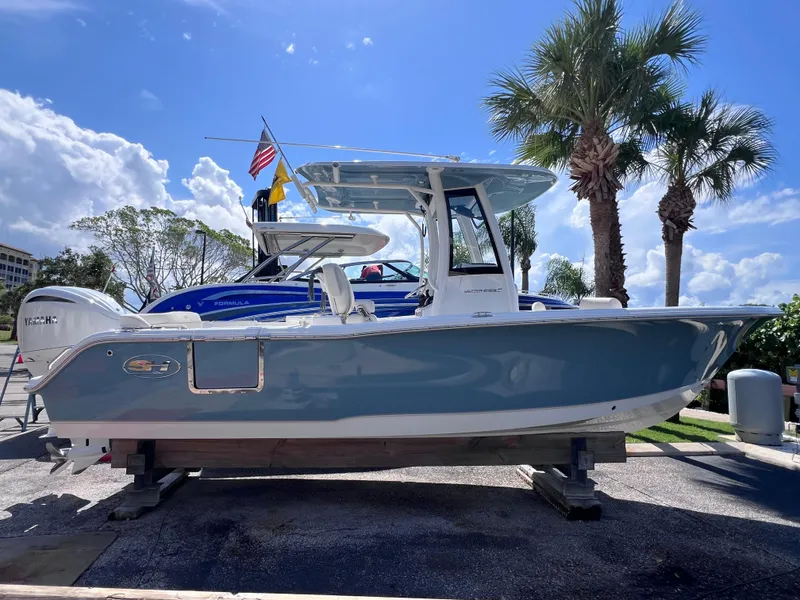 Slide: The Image of 2024 Sea Hunt Ultra 239 SE boat displayed outdoors with palm trees and blue sky. - 15