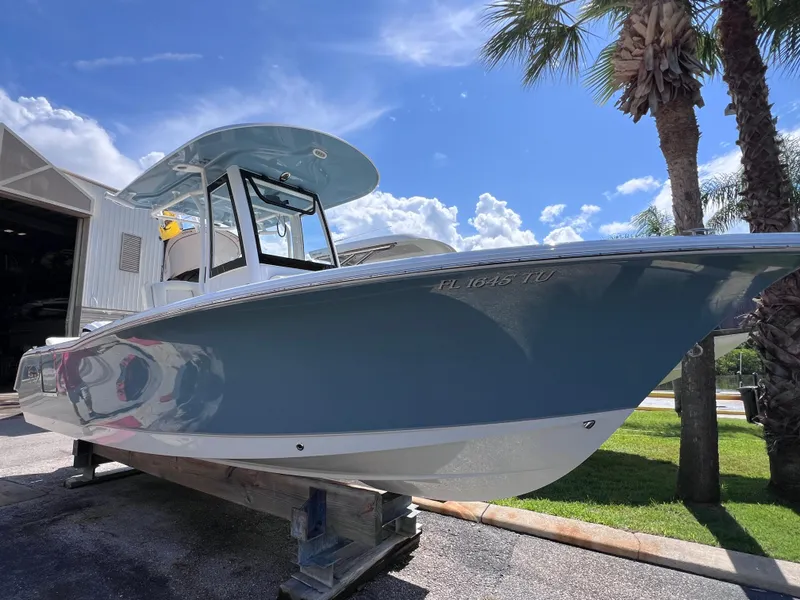 Slide: The Image of 2024 Sea Hunt Ultra 239 SE boat on display under a clear blue sky. - 16
