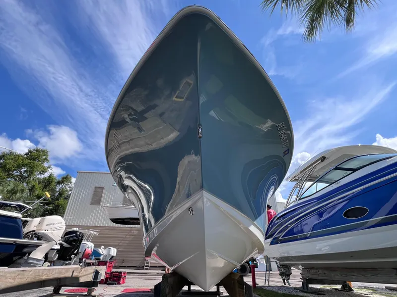 Slide: The Image of 2024 Sea Hunt Ultra 239 SE boat displayed outdoors under a clear blue sky. - 18