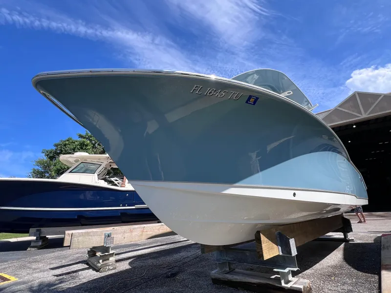 Slide: The Image of 2024 Sea Hunt Ultra 239 SE boat on display under a clear blue sky. - 19