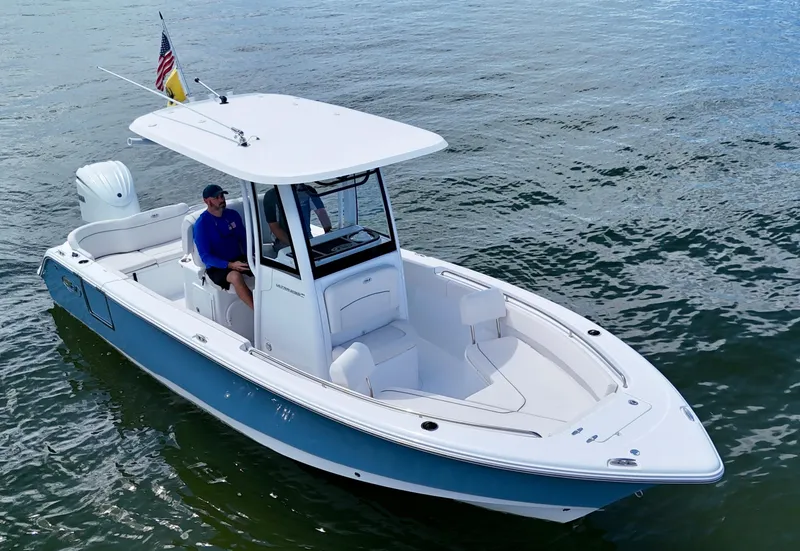 Slide: The Image of 2024 Sea Hunt Ultra 239 SE boat on water, featuring sleek design and spacious seating. - 2