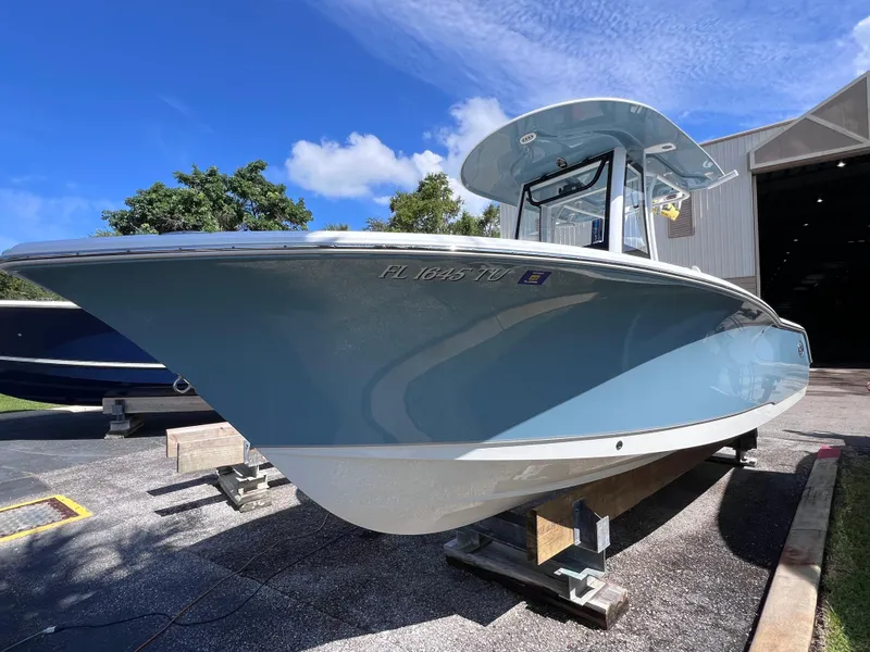 Slide: The Image of 2024 Sea Hunt Ultra 239 SE boat on display under a clear blue sky. - 20