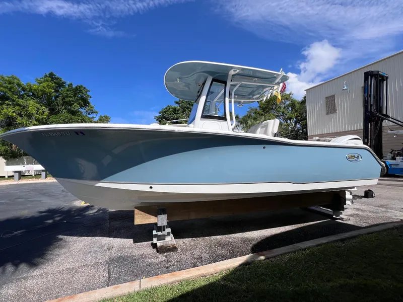 Slide: The Image of 2024 Sea Hunt Ultra 239 SE boat on display under clear blue sky. - 21