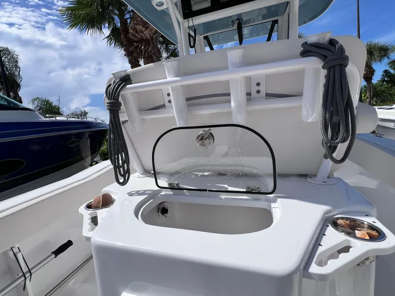 Slide: The Image of 2024 Sea Hunt Ultra 239 SE boat interior with storage compartment and cup holders. - 36