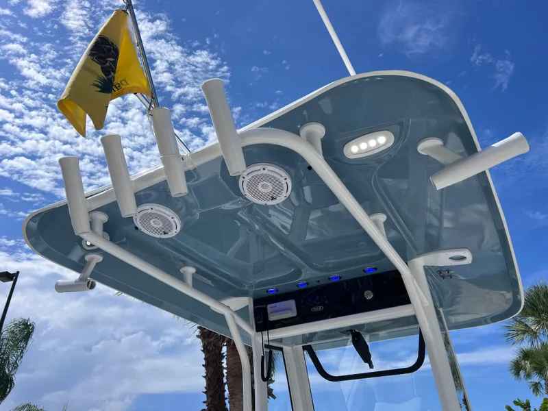 Slide: The Image of 2024 Sea Hunt Ultra 239 SE boat top with rod holders and speakers against blue sky. - 42