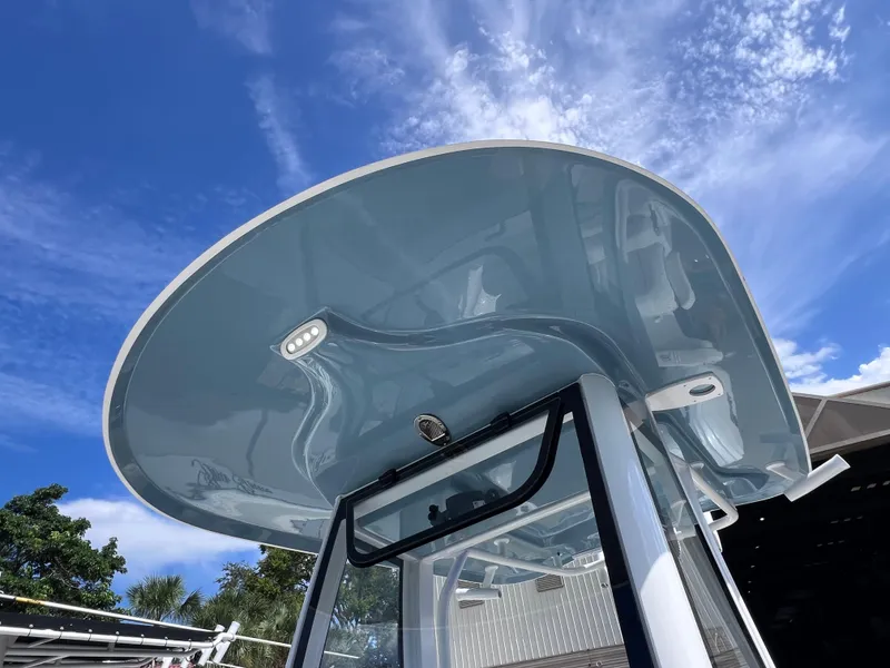 Slide: The Image of 2024 Sea Hunt Ultra 239 SE boat with sleek T-top against a clear blue sky. - 43