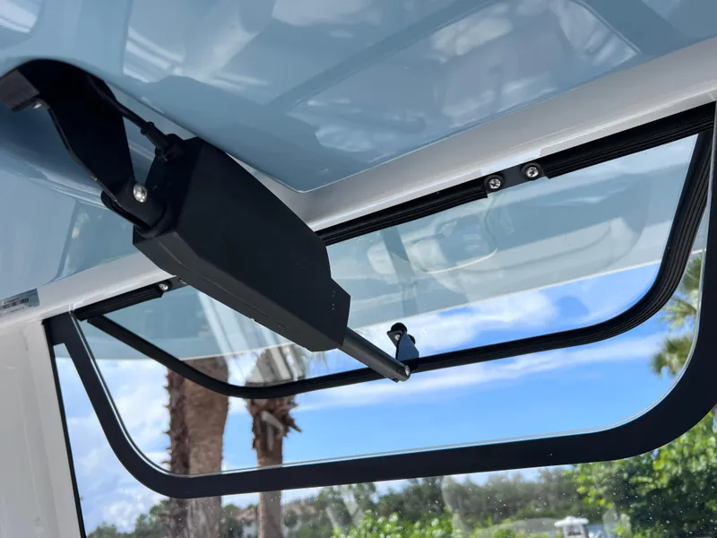 Slide: The Image of 2024 Sea Hunt Ultra 239 SE boat windshield detail with clear sky and palm trees. - 45