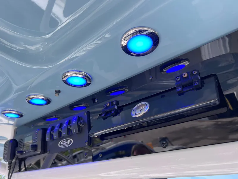 Slide: The Image of 2024 Sea Hunt Ultra 239 SE boat with blue LED lights and control panel. - 47