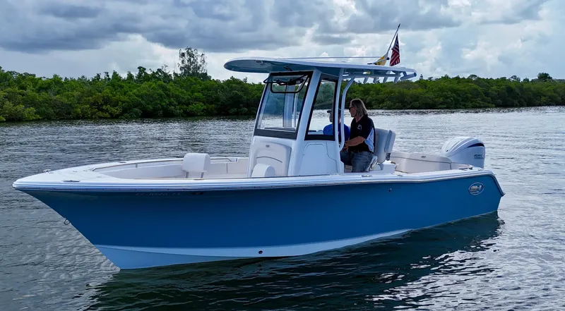 Slide: The Image of 2024 Sea Hunt Ultra 239 SE boat on water, featuring sleek blue design. - 7