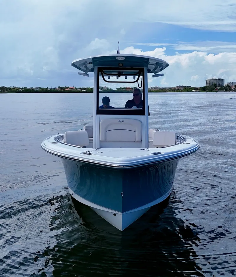 Slide: The Image of 2024 Sea Hunt Ultra 239 SE boat on calm water, front view. - 8