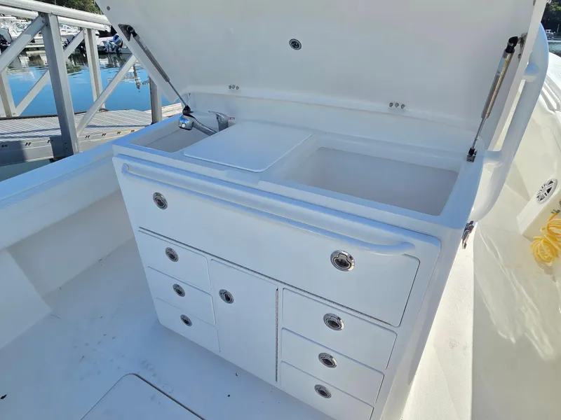 Slide: The Image of 2021 Regulator 31 CC boat with open storage compartments and sink. - 15