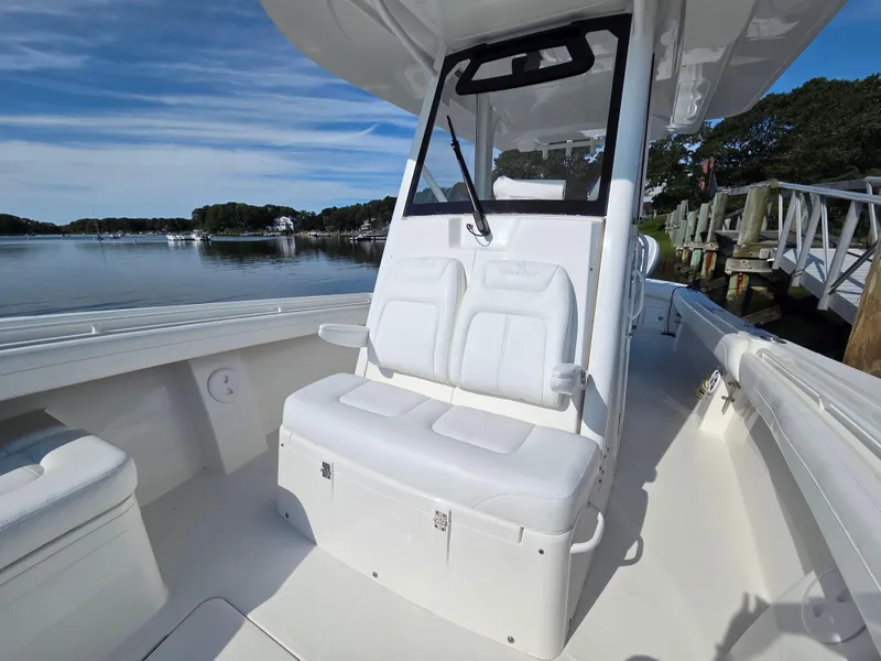 Slide: The Image of 2021 Regulator 31 CC boat interior with white seating, docked by calm waters. - 19