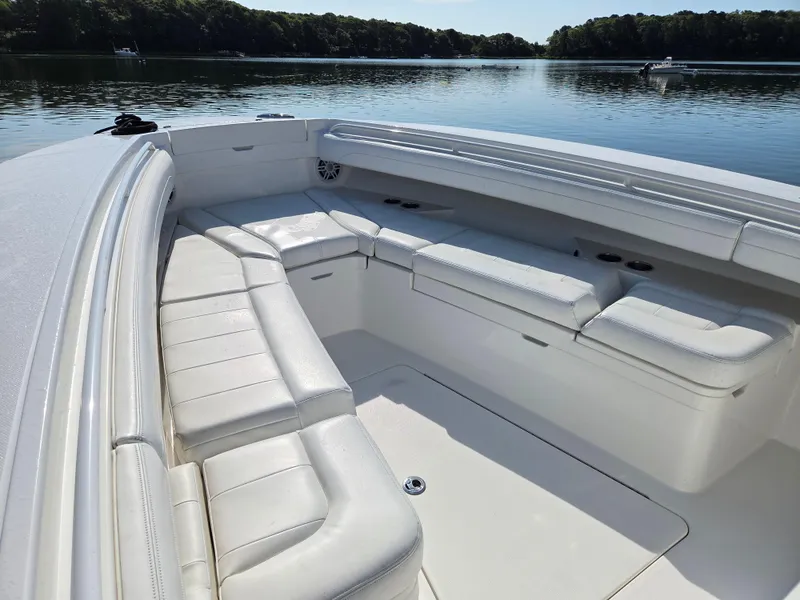 Slide: The Image of 2021 Regulator 31 CC boat with spacious white seating, docked on a calm lake. - 21
