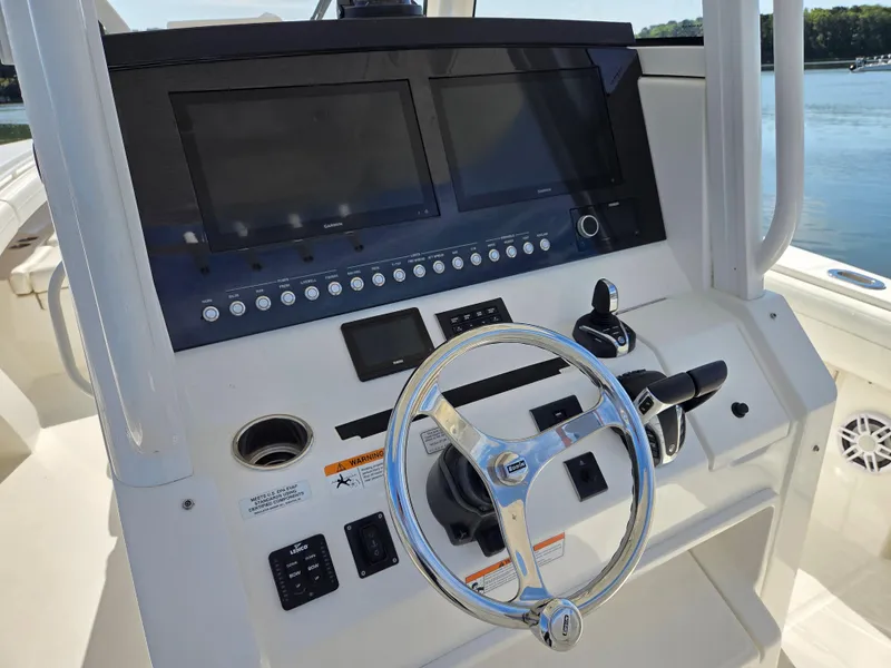 Slide: The Image of 2021 Regulator 31 CC boat dashboard with steering wheel and electronic controls. - 9