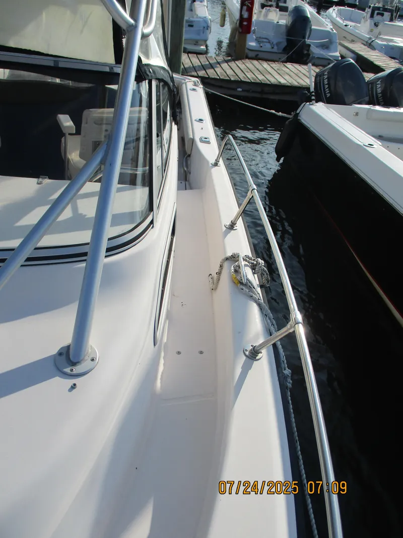 Slide: The Image of 1998 Grady-White 226 Seafarer WA boat docked, showing deck and railing details. - 11