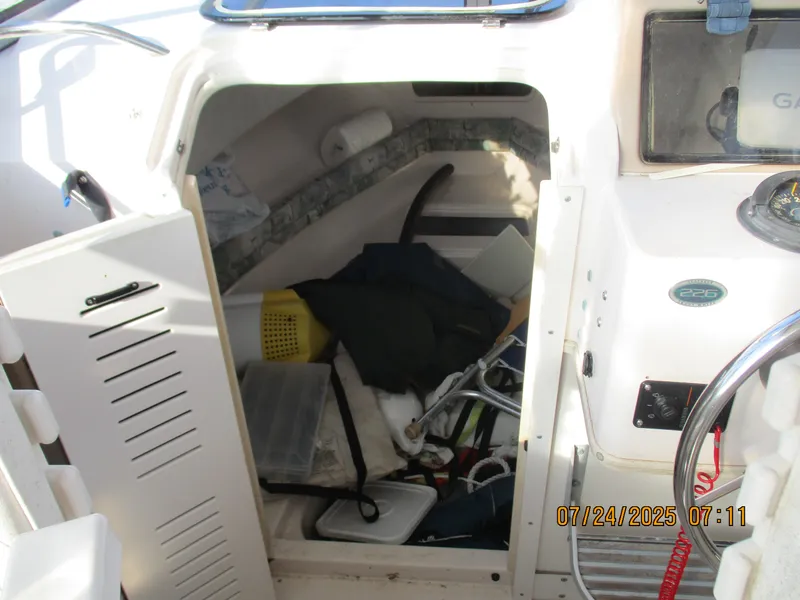 Slide: The Image of 1998 Grady-White 226 Seafarer WA cabin with open storage compartment and boating gear. - 5