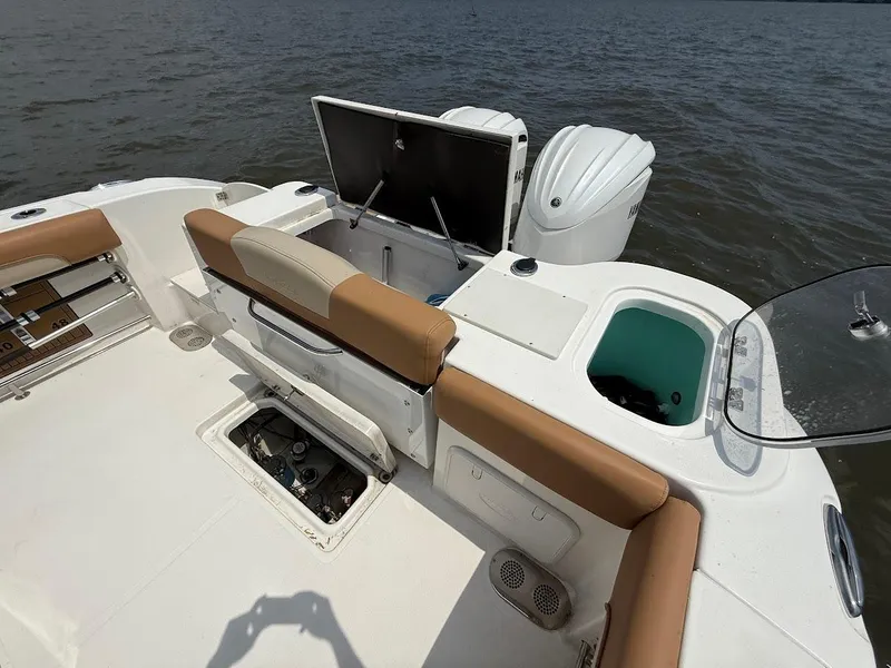Slide: The Image of 2023 NauticStar 28 XS boat interior with tan seating and open storage compartments. - 11