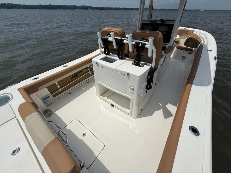 Slide: The Image of 2023 NauticStar 28 XS boat interior with seating and console on calm water. - 13