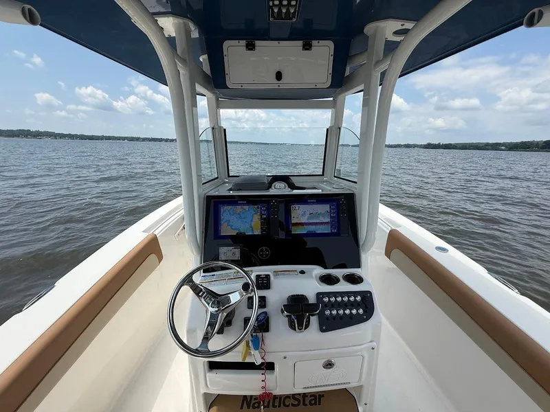Slide: The Image of 2023 NauticStar 28 XS boat dashboard with navigation screens on open water. - 19