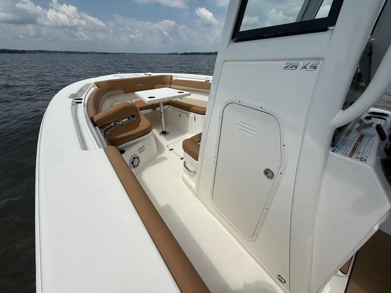 Slide: The Image of 2023 NauticStar 28 XS boat interior with seating and table on open water. - 22