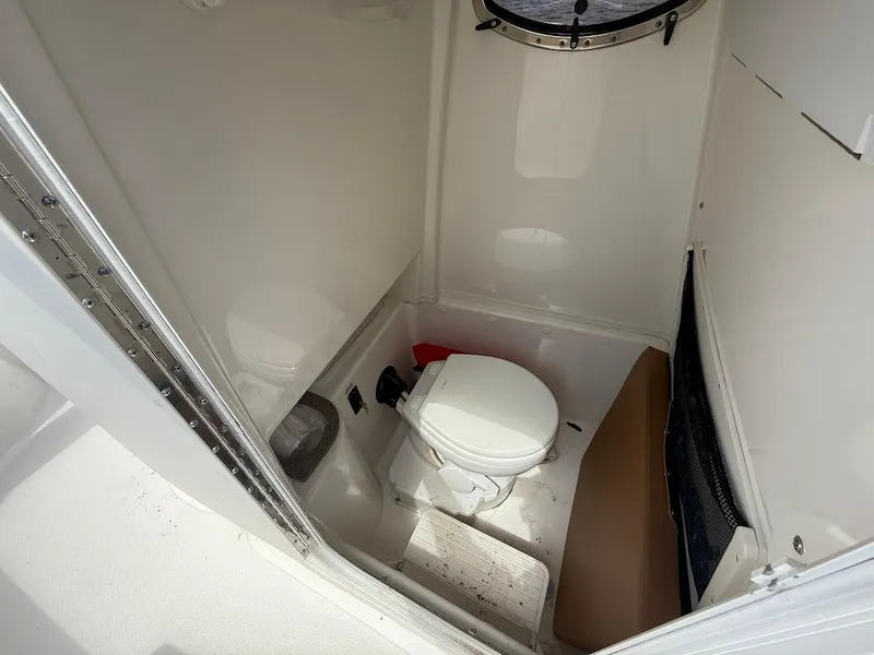 Slide: The Image of 2023 NauticStar 28 XS boat interior with compact marine toilet. - 23