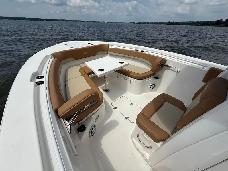Slide: The Image of 2023 NauticStar 28 XS boat interior with tan seating and table on open water. - 24