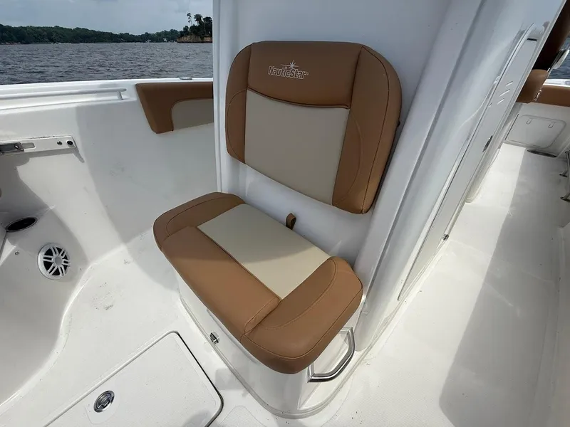 Slide: The Image of 2023 NauticStar 28 XS boat seat with tan and cream upholstery, on a sunny day. - 25