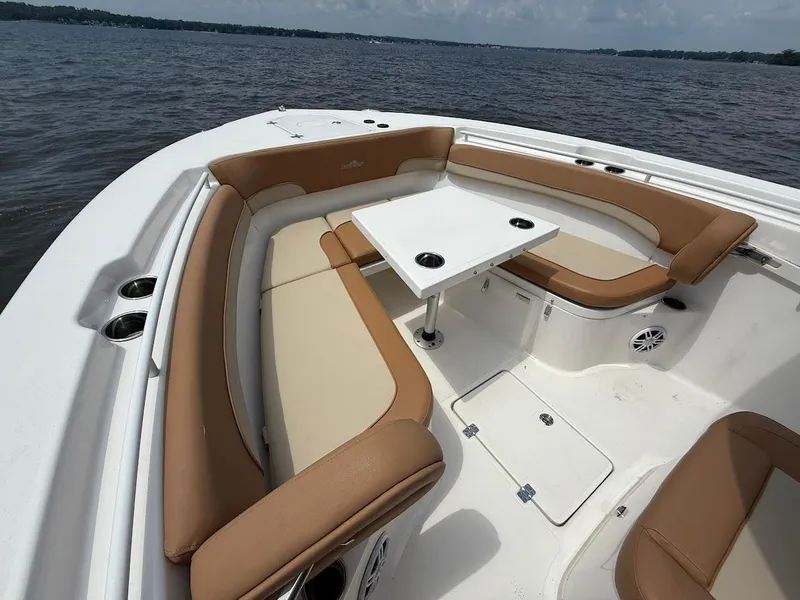 Slide: The Image of 2023 NauticStar 28 XS boat with tan seating and white table on open water. - 26