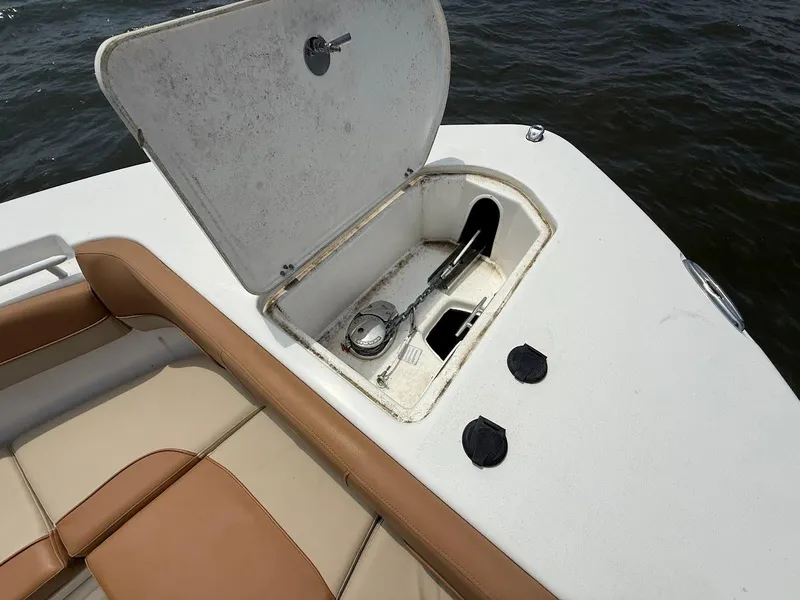 Slide: The Image of 2023 NauticStar 28 XS boat anchor compartment with open hatch, showing anchor and chain. - 28