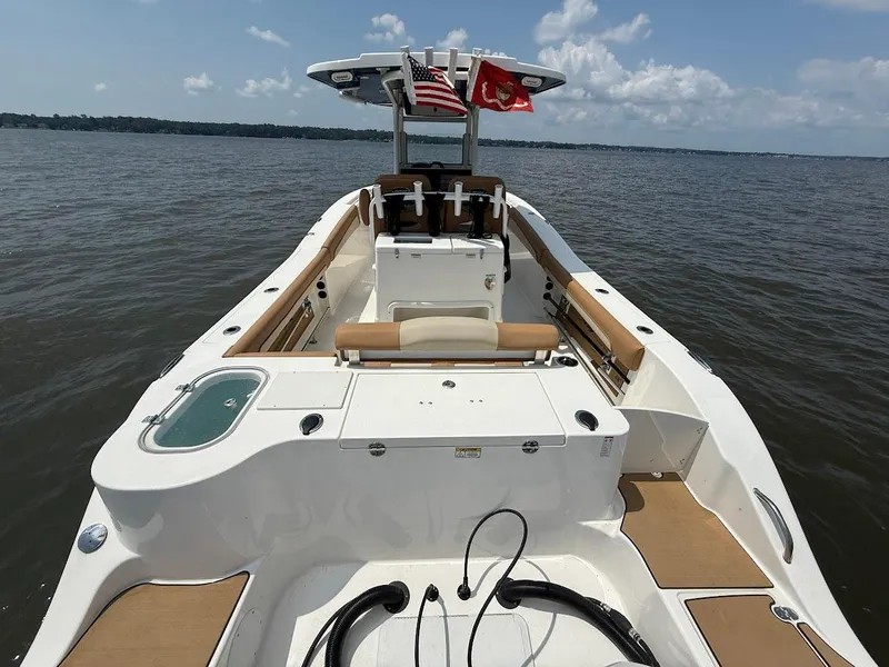 Slide: The Image of 2023 NauticStar 28 XS boat on water, featuring spacious deck and seating. - 8