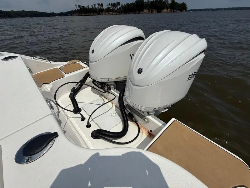 Slide: The Image of 2023 NauticStar 28 XS boat with dual Yamaha outboard motors on a lake. - 9