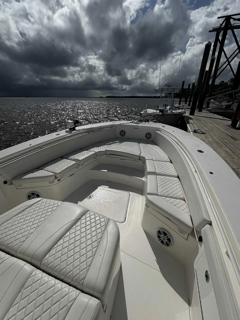 Slide: The Image of 2023 Regulator 30XO boat with white seating, docked under cloudy skies. - 3