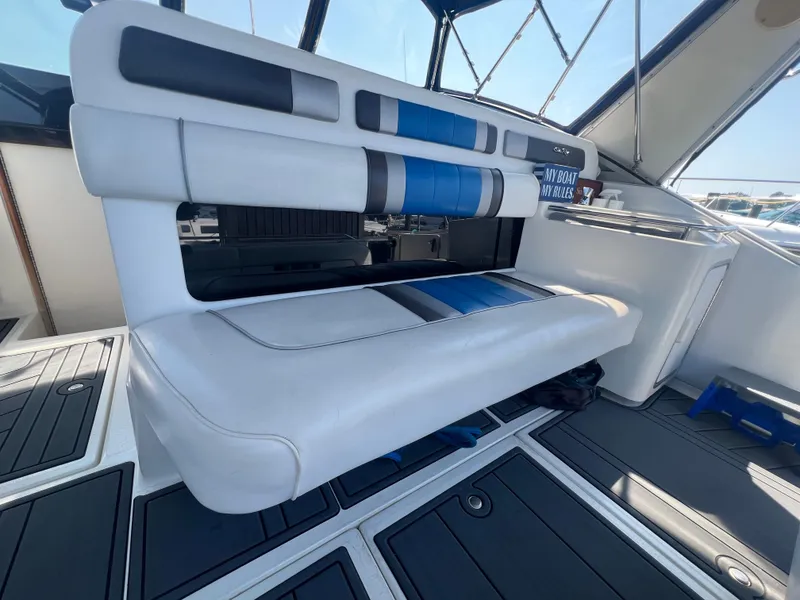Slide: The Image of 1991 Sea Ray 310 Sundancer interior with cushioned seating and nautical decor. - 11