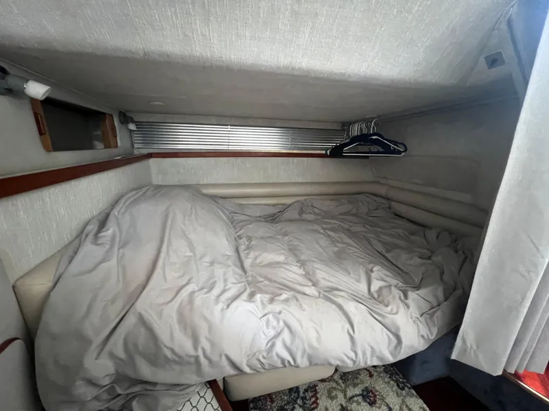 Slide: The Image of Cozy cabin interior of 1991 Sea Ray 310 Sundancer with bed and hangers. - 19