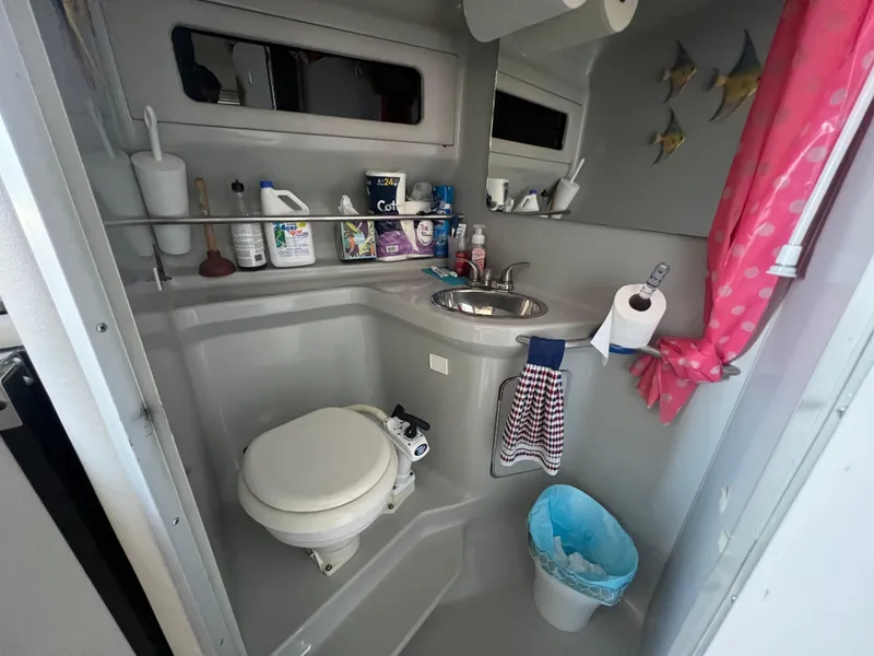 Slide: The Image of Bathroom interior of 1991 Sea Ray 310 Sundancer with sink, toilet, and storage shelves. - 21