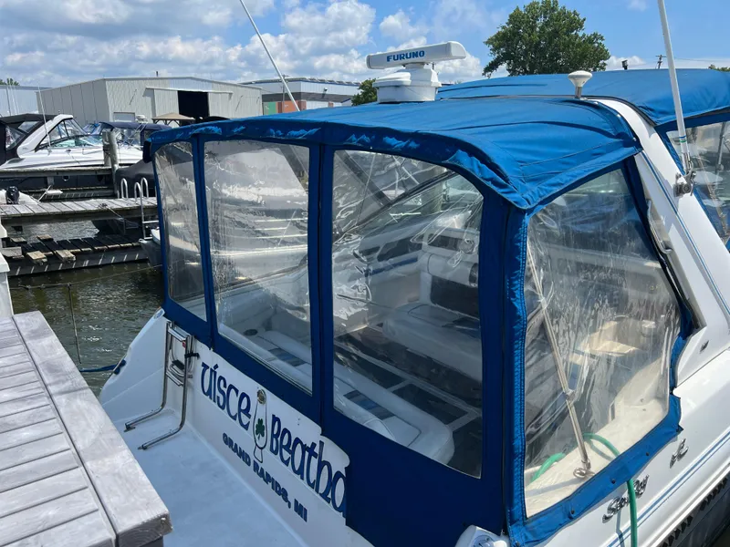 Slide: The Image of 1991 Sea Ray 310 Sundancer docked with blue canopy and clear windows. - 3