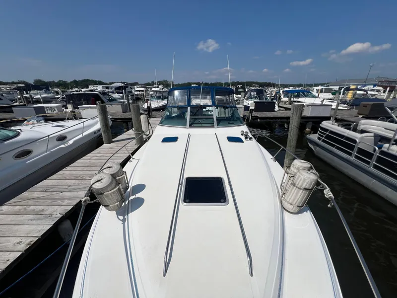 Slide: The Image of 1991 Sea Ray 310 Sundancer docked at marina, surrounded by other boats under clear blue sky. - 6