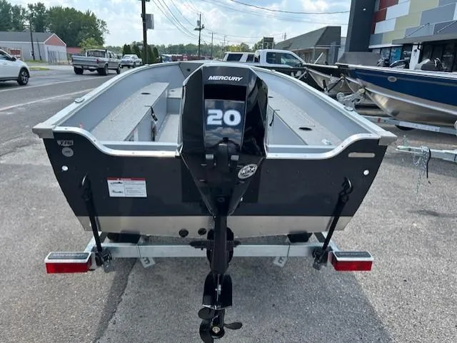 Slide: The Image of 2026 Lund 1600 Fury Tiller boat with Mercury 20 engine, parked on a trailer. - 2