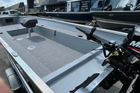 Slide: The Image of 2026 Lund 1600 Fury Tiller boat with motor, parked outdoors. - 7