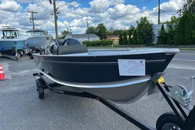 Slide: The Image of 2026 Lund 1600 Fury SS boat on trailer, parked outdoors under a cloudy sky. - 1