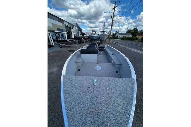 Slide: The Image of 2026 Lund 1600 Fury SS boat parked outdoors under a cloudy sky. - 4
