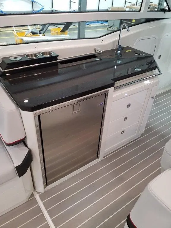 Slide: The Image of 2020 Formula 430 Super Sport Crossover boat interior with sleek kitchenette and stainless steel fridge. - 28
