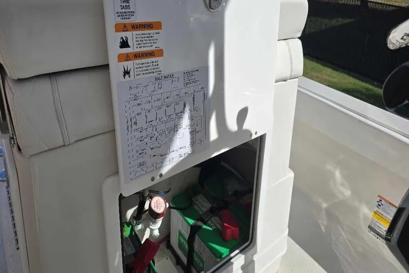 Slide: The Image of 2025 Ranger 2360 Bay boat interior with storage compartment and warning labels. - 12