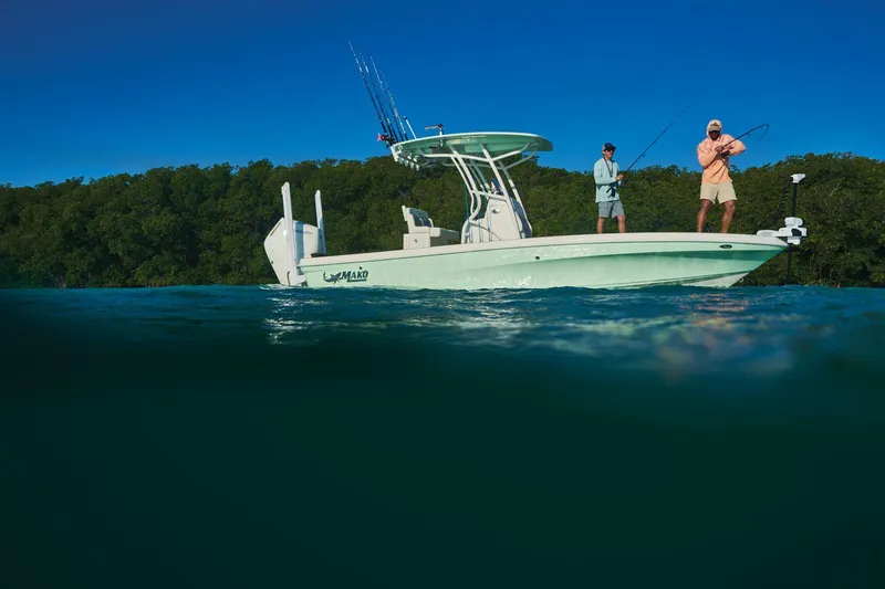 Slide: The Image of 2025 Mako 24 APEX boat on trailer, parked outdoors, showcasing sleek design and modern features. - 3