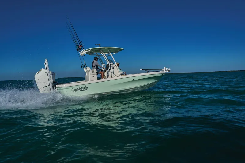 Slide: The Image of 2025 Mako 24 APEX boat with modern console and seating, parked outdoors. - 6