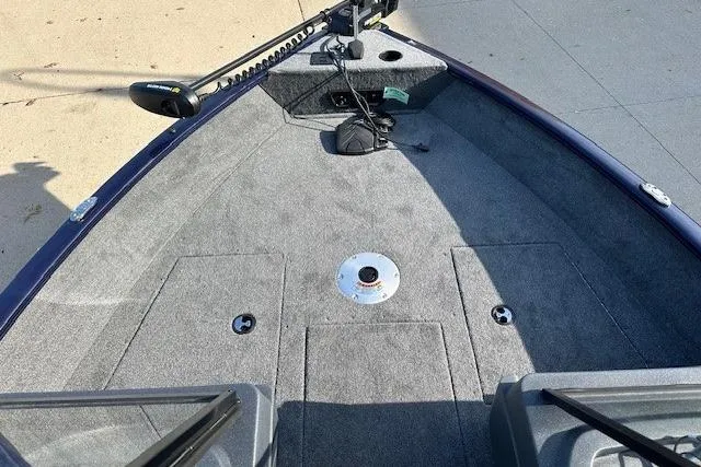 Slide: The Image of 2025 Tracker Pro Guide V-175 Combo boat interior with carpeted deck and trolling motor. - 4