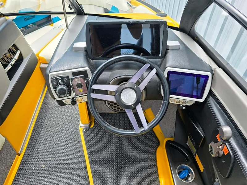 Slide: The Image of 2015 Malibu Wakesetter 22 VLX Surf Gate dashboard with steering wheel and digital displays. - 13