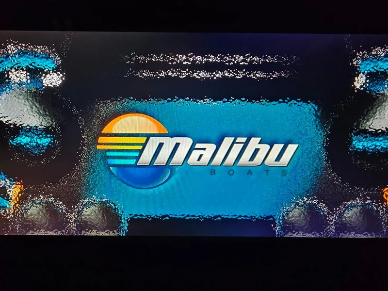 Slide: The Image of Malibu Boats logo with water-themed design, 2015 Wakesetter 22 VLX Surf Gate. - 18