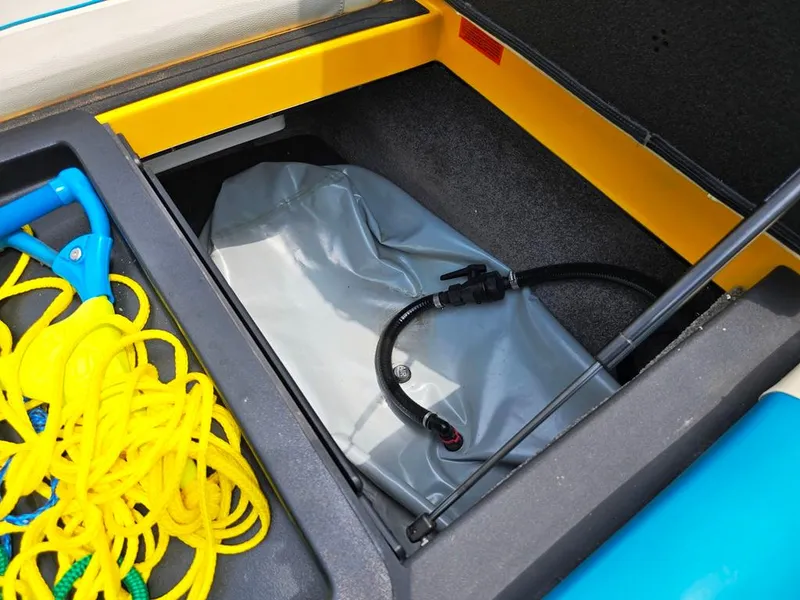Slide: The Image of Storage compartment of 2015 Malibu Wakesetter 22 VLX with yellow rope and equipment. - 25